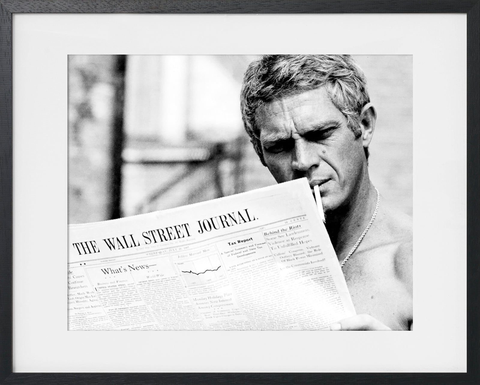 PORTRAIT OF STEVE MCQUEEN READING THE WALL STREET JOURNAL, 1967
